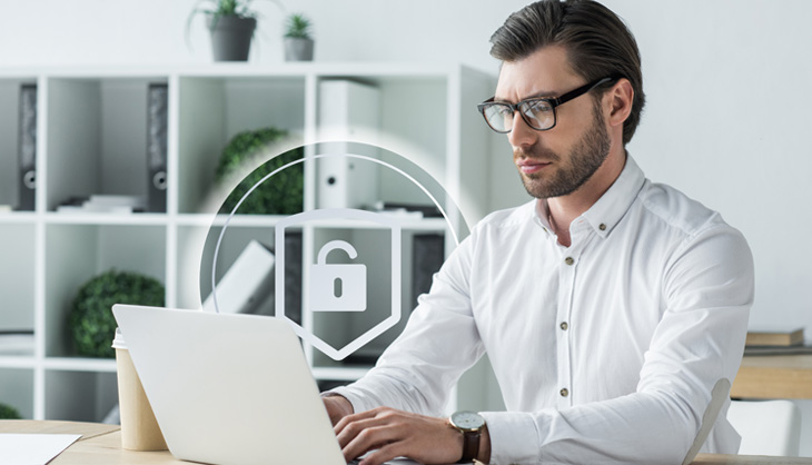 Mann vor Laptop mit Sicherheitssymbolen