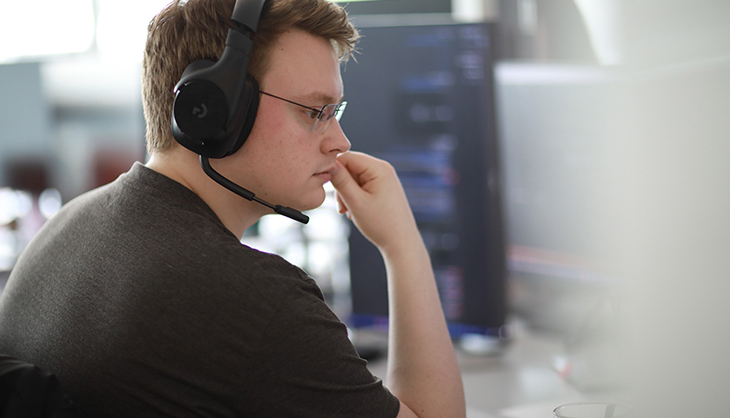 IT employee works with headset on PC