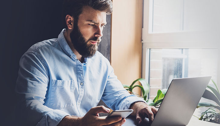 Man working with smartphone and laptop